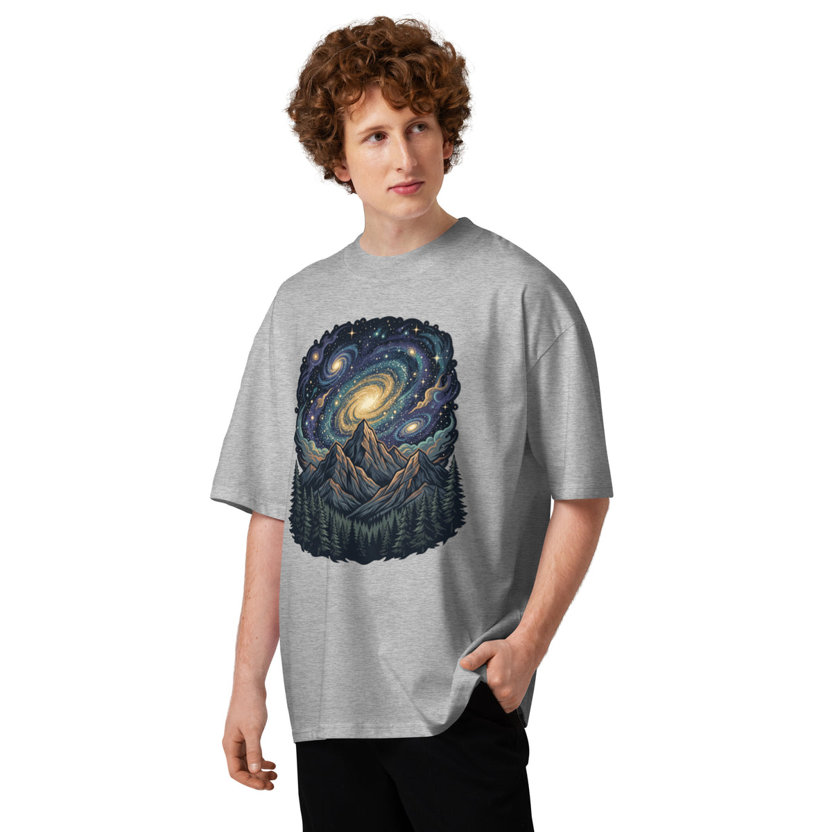 Spiral galaxy above pine-covered mountains on a heather grey oversized high-neck tee, front view