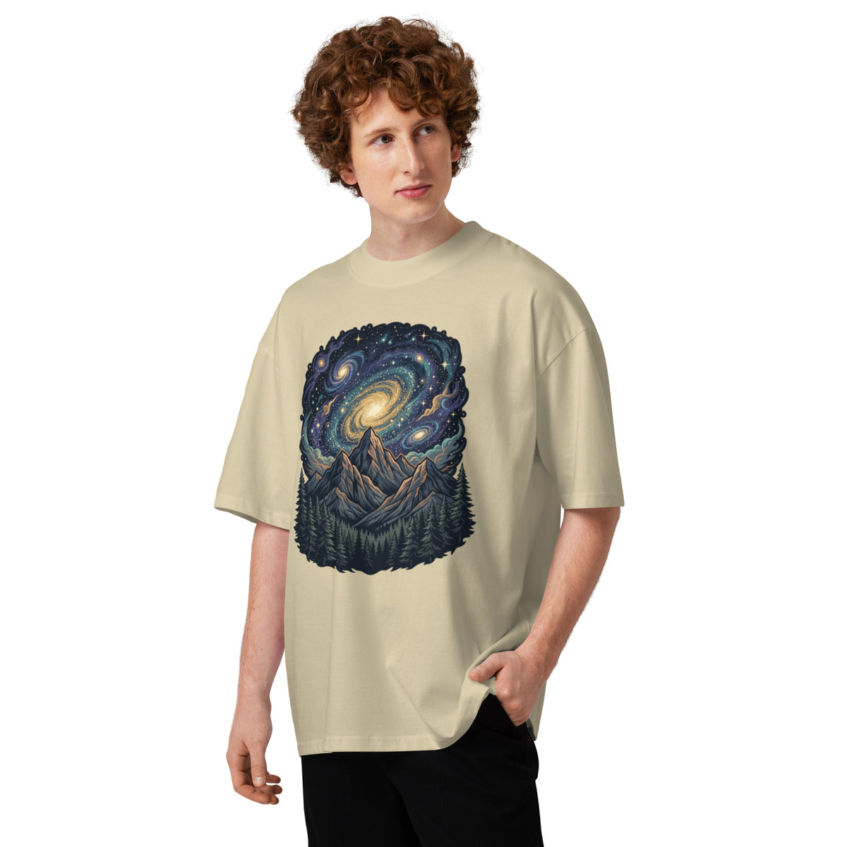 Spiral galaxy above pine-covered mountains on a stone oversized high-neck tee, front view