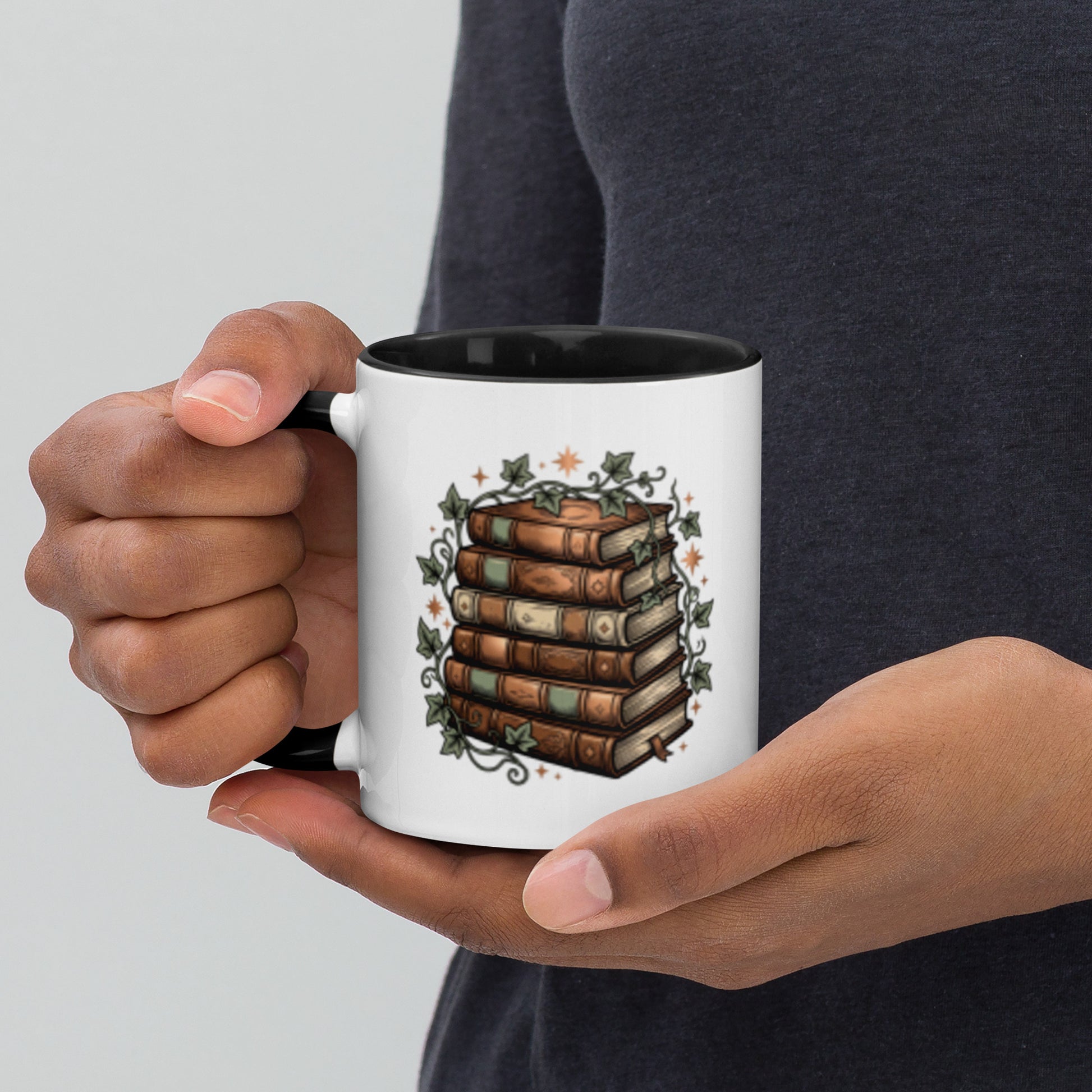 Stacked books and ivy design on a white ceramic mug with black rim and handle, 11 oz, left view