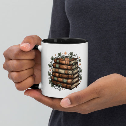 Stacked books and ivy design on a white ceramic mug with black rim and handle, 11 oz, left view