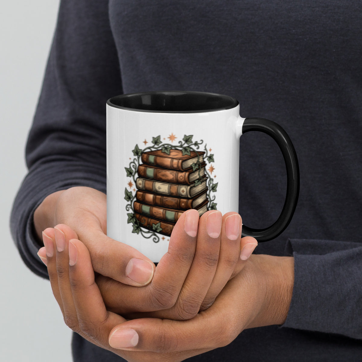 Stacked books and ivy design on a white ceramic mug with black rim and handle, 11 oz, right view