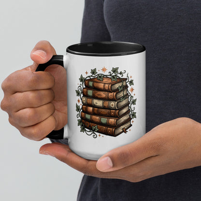 Stacked books and ivy design on a white ceramic mug with black rim and handle, 15 oz, left view