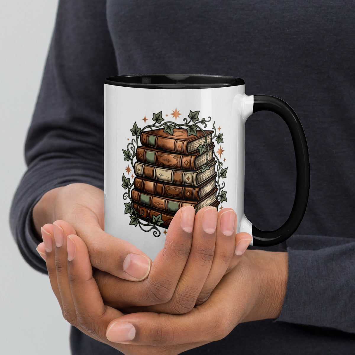 Stacked books and ivy design on a white ceramic mug with black rim and handle, 15 oz, right view