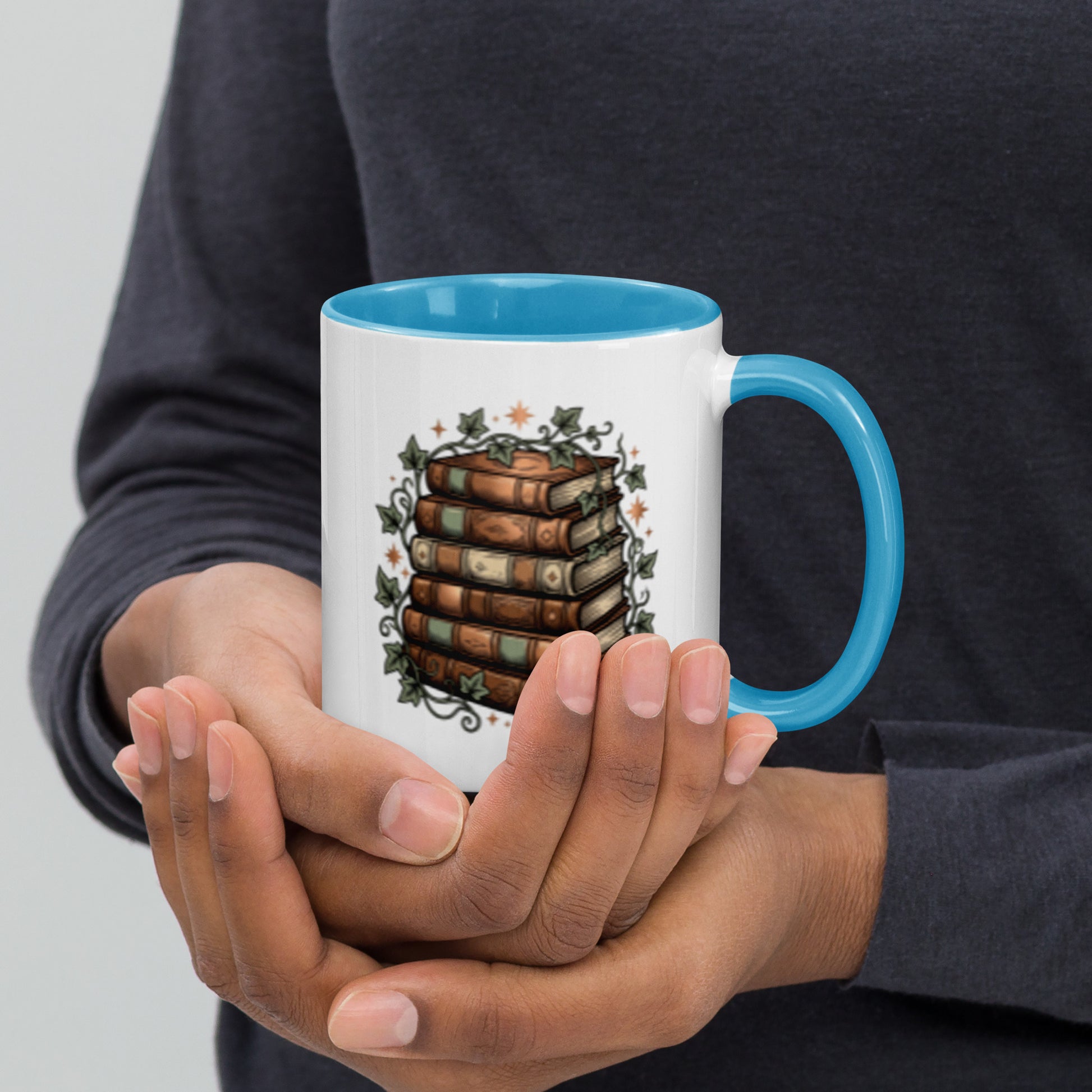 Stacked books and ivy design on a white ceramic mug with blue rim and handle, 11 oz, right view