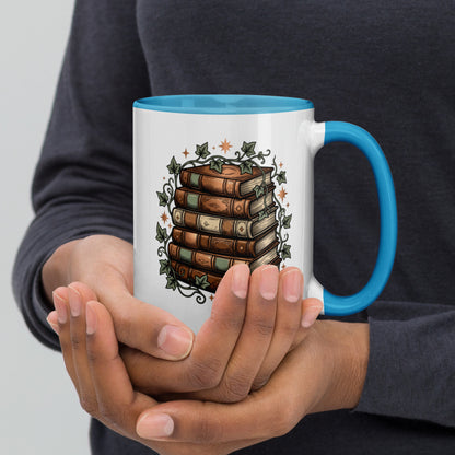 Stacked books and ivy design on a white ceramic mug with blue rim and handle, 15 oz, right view