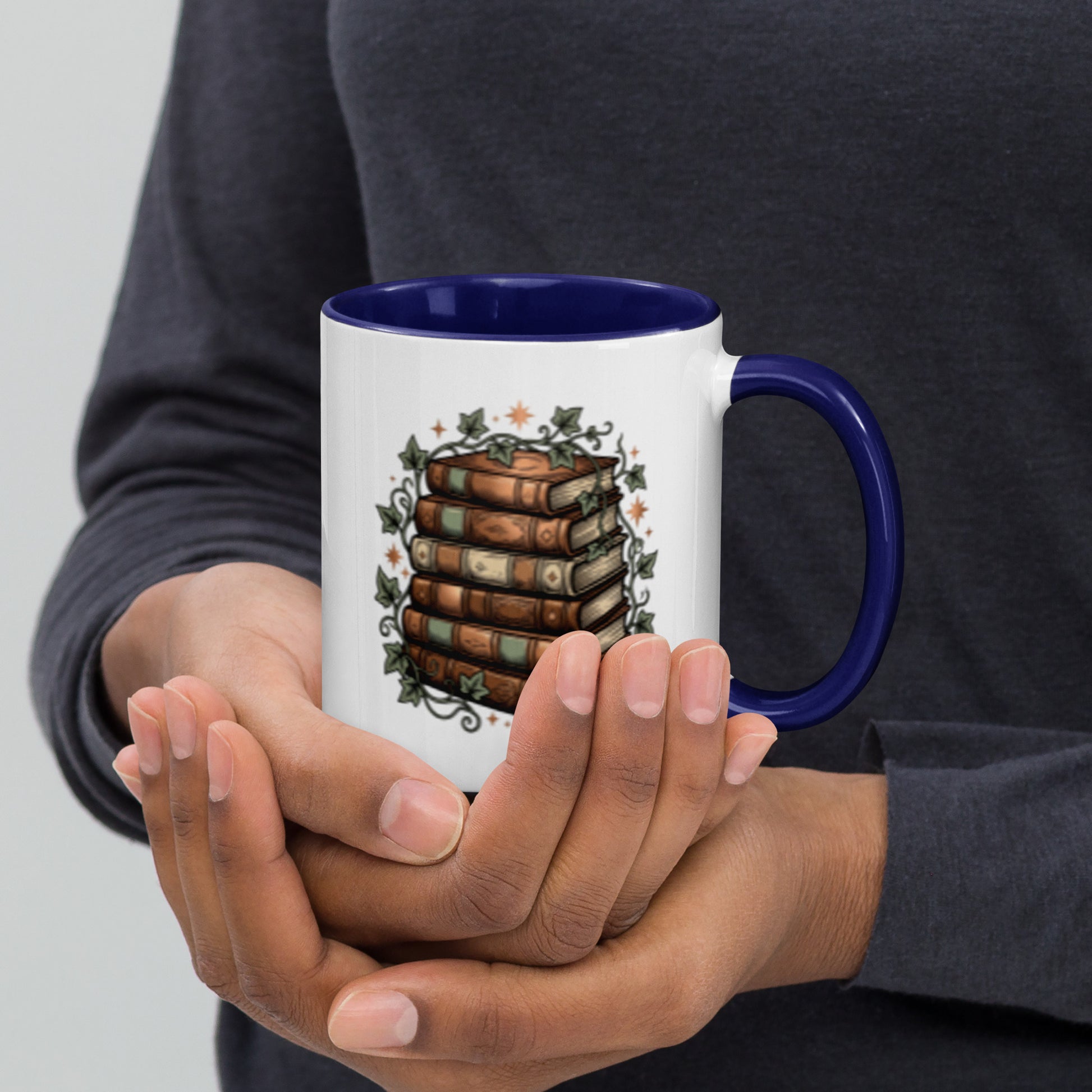 Stacked books and ivy design on a white ceramic mug with dark blue rim and handle, 11 oz, right view