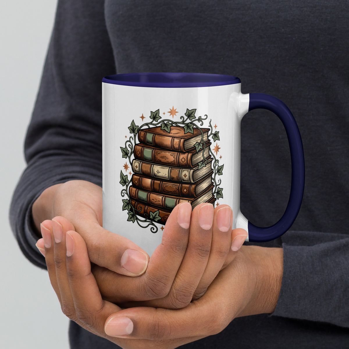 Stacked books and ivy design on a white ceramic mug with dark blue rim and handle, 15 oz, right view