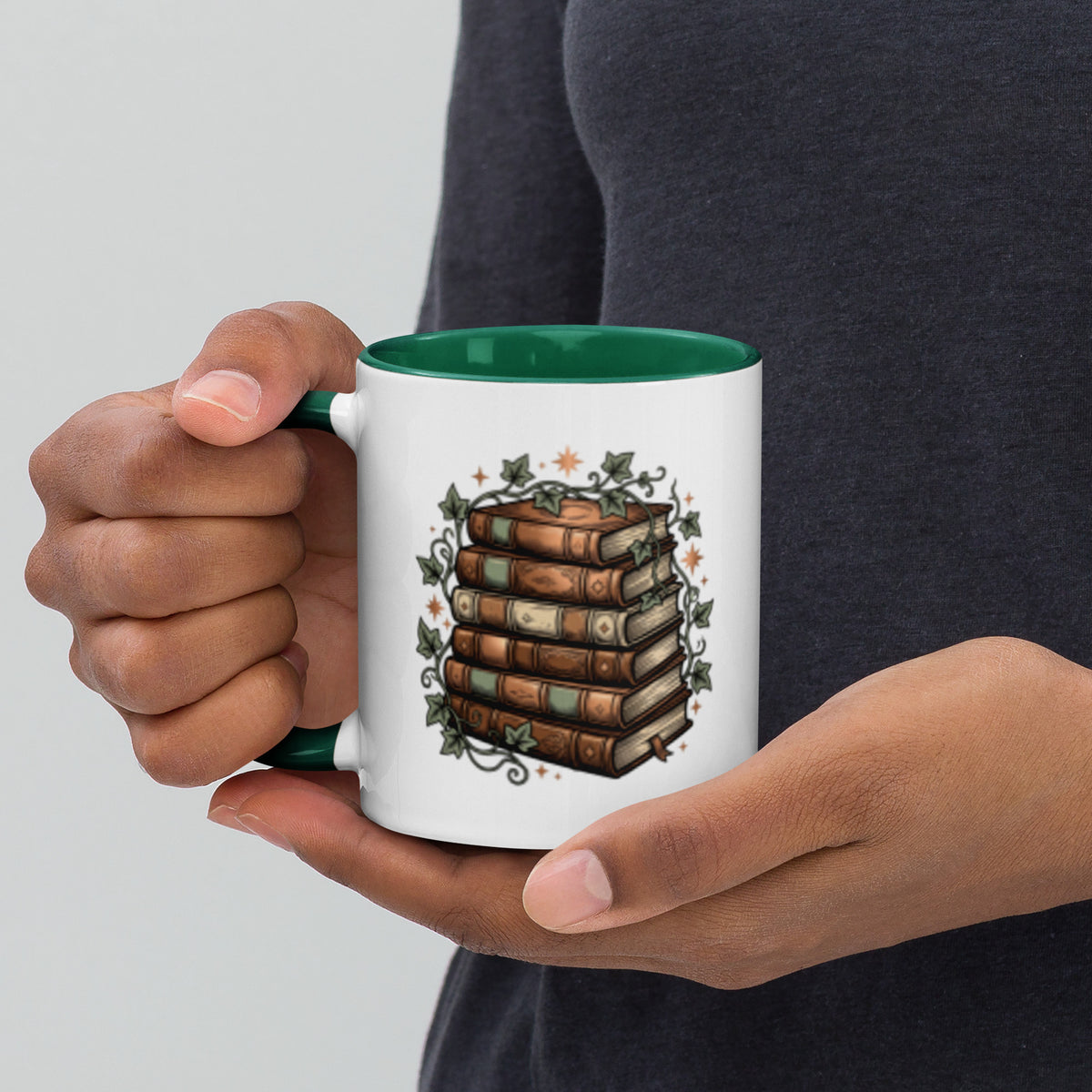 Stacked books and ivy design on a white ceramic mug with dark green rim and handle, 11 oz, left view