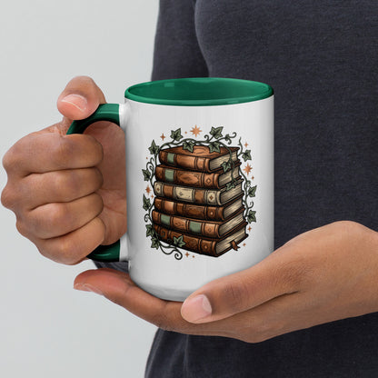 Stacked books and ivy design on a white ceramic mug with dark green rim and handle, 15 oz, left view