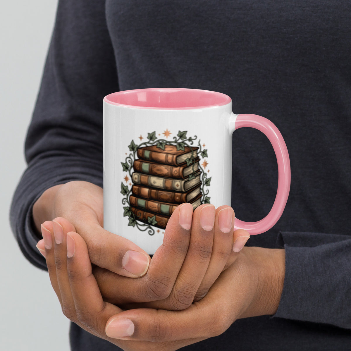 Stacked books and ivy design on a white ceramic mug with pink rim and handle, 11 oz, right view