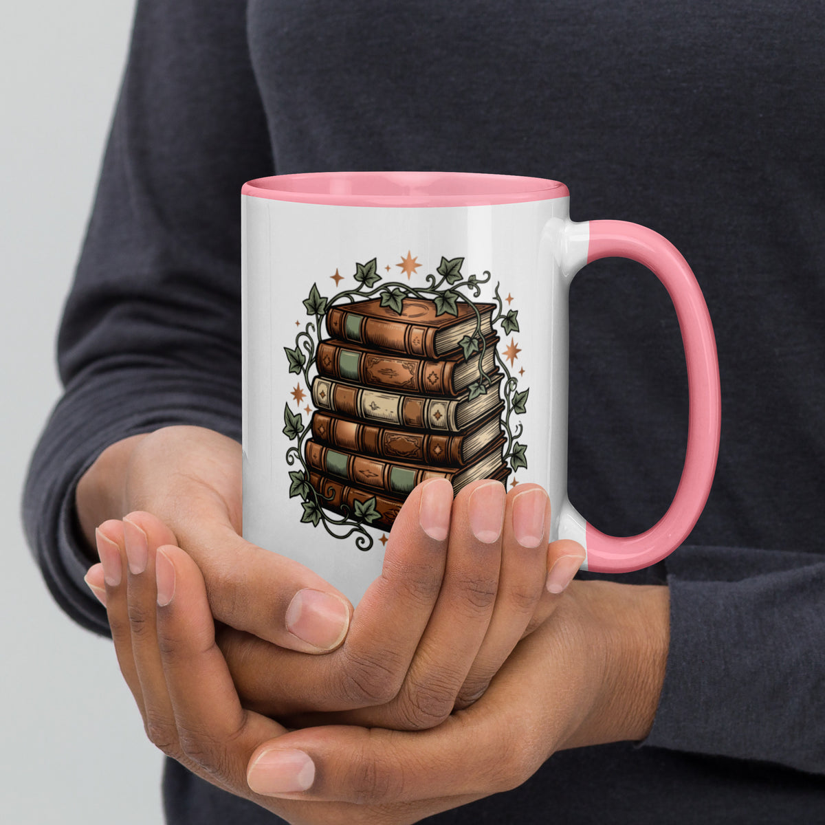 Stacked books and ivy design on a white ceramic mug with pink rim and handle, 15 oz, right view