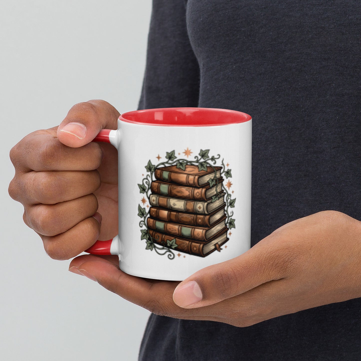 Stacked books and ivy design on a white ceramic mug with red rim and handle, 11 oz, left view