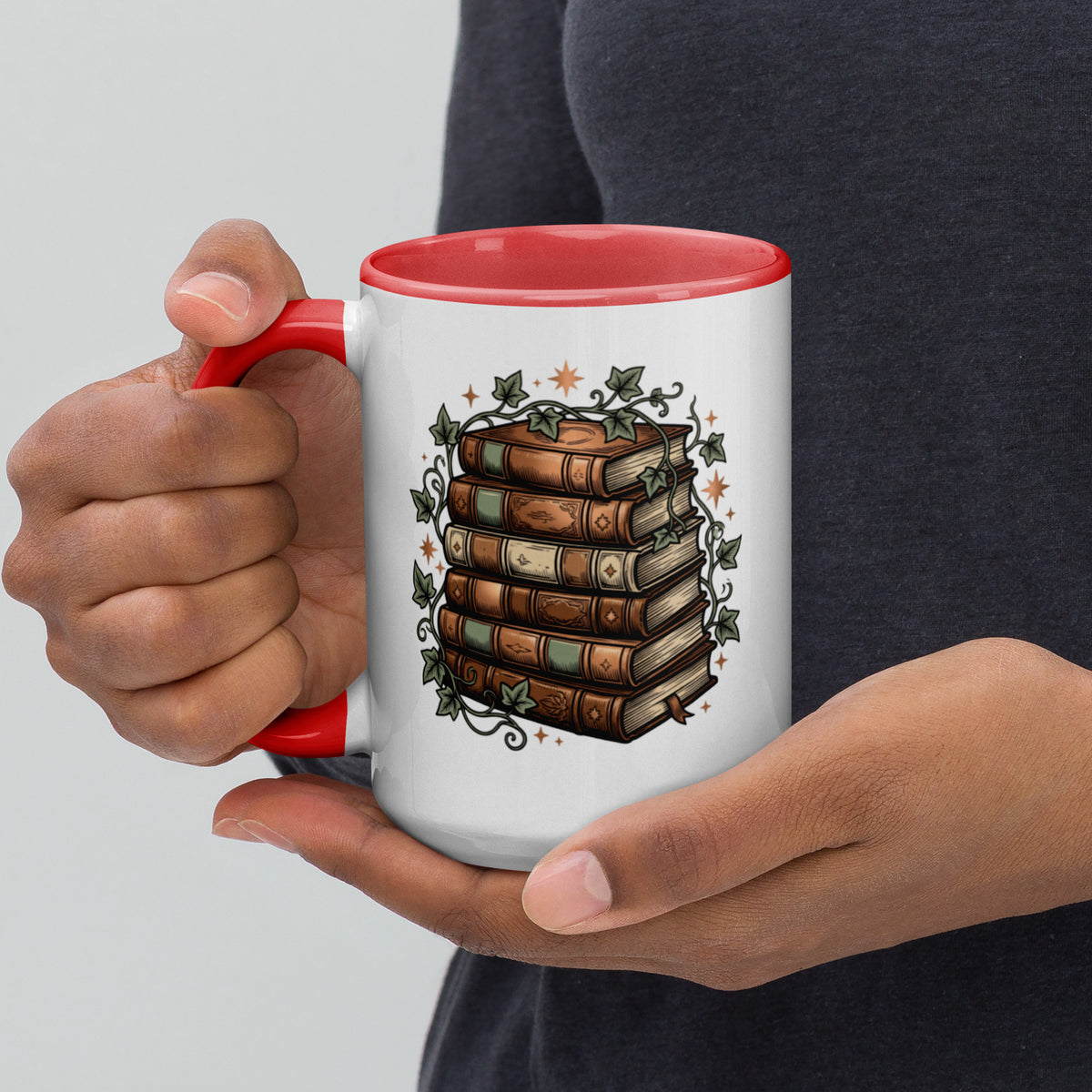 Stacked books and ivy design on a white ceramic mug with red rim and handle, 15 oz, left view