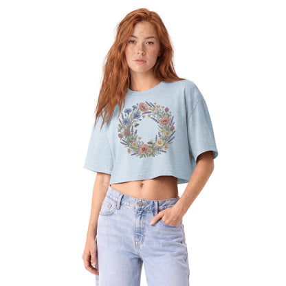 Pastel wildflower wreath printed on a light washed denim garment-dyed cropped tee, front view
