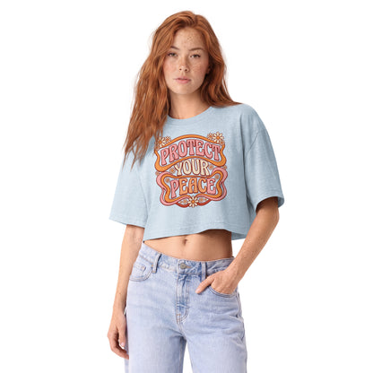 Protect Your Peace in groovy retro lettering on a light washed denim garment-dyed cropped tee, front view