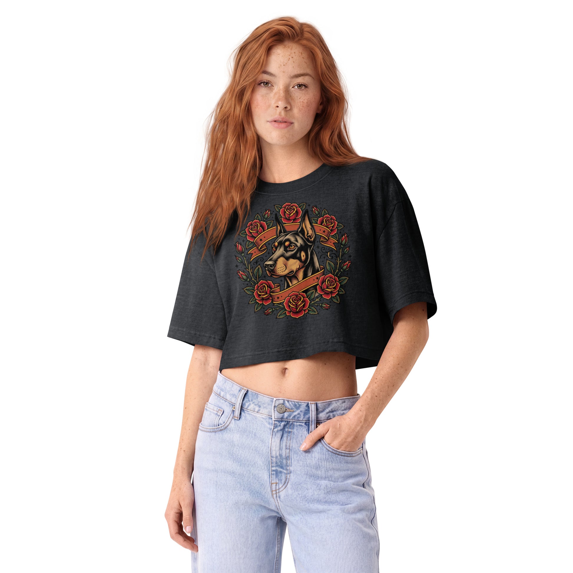Tattoo-style Doberman framed in red roses on a washed black garment-dyed cropped tee, front view